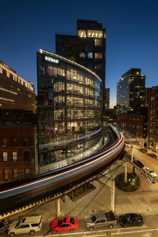 a train traveling over a train station with tall buildings