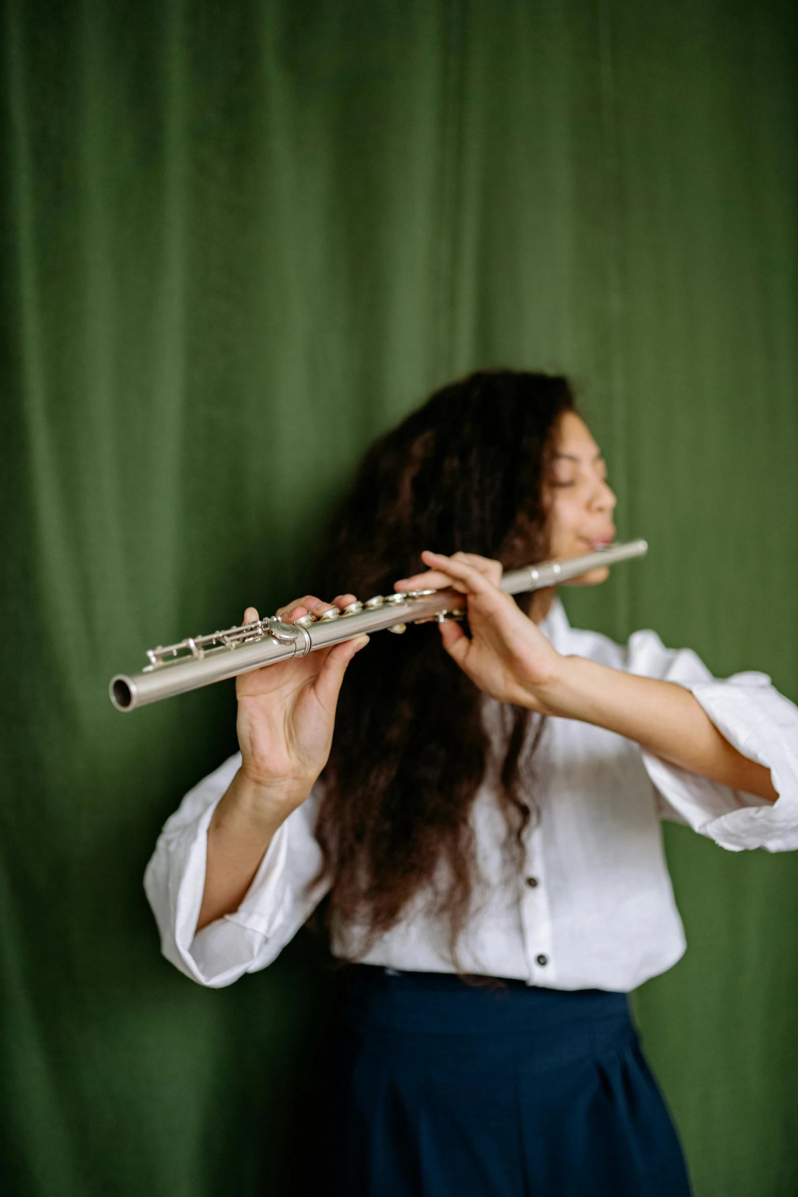 a woman wearing a shirt and holding onto the keys of a flute