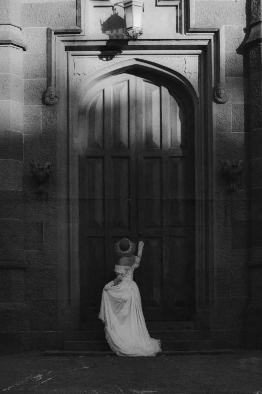 a woman in a dress and umbrella standing in front of a doorway