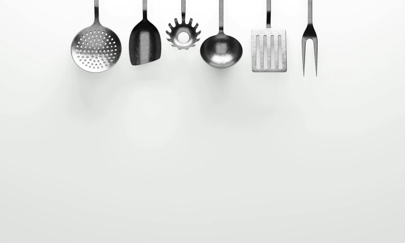 a white wall is holding a rack of utensils