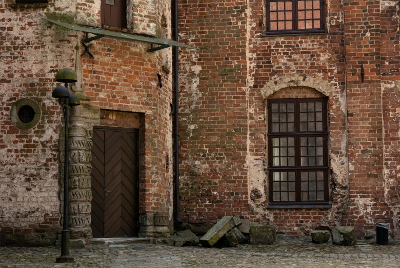 a very tall brick building with windows, a sign and two fire hydrant