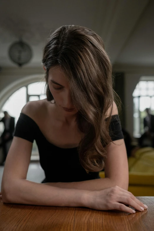 a woman sitting at a wooden table in an old el