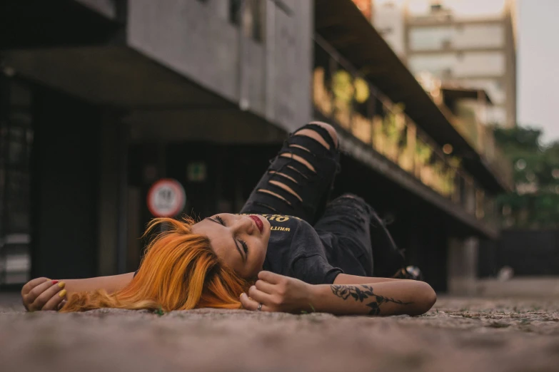 a girl laying on the ground with her eyes closed