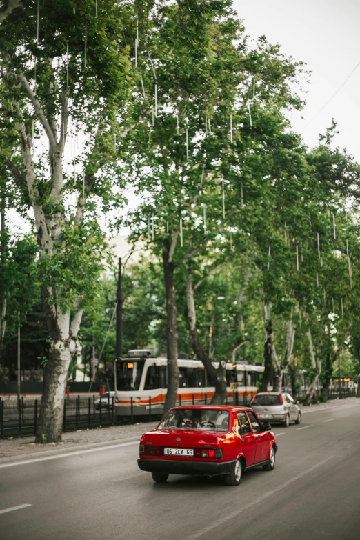 an old red car driving on a street