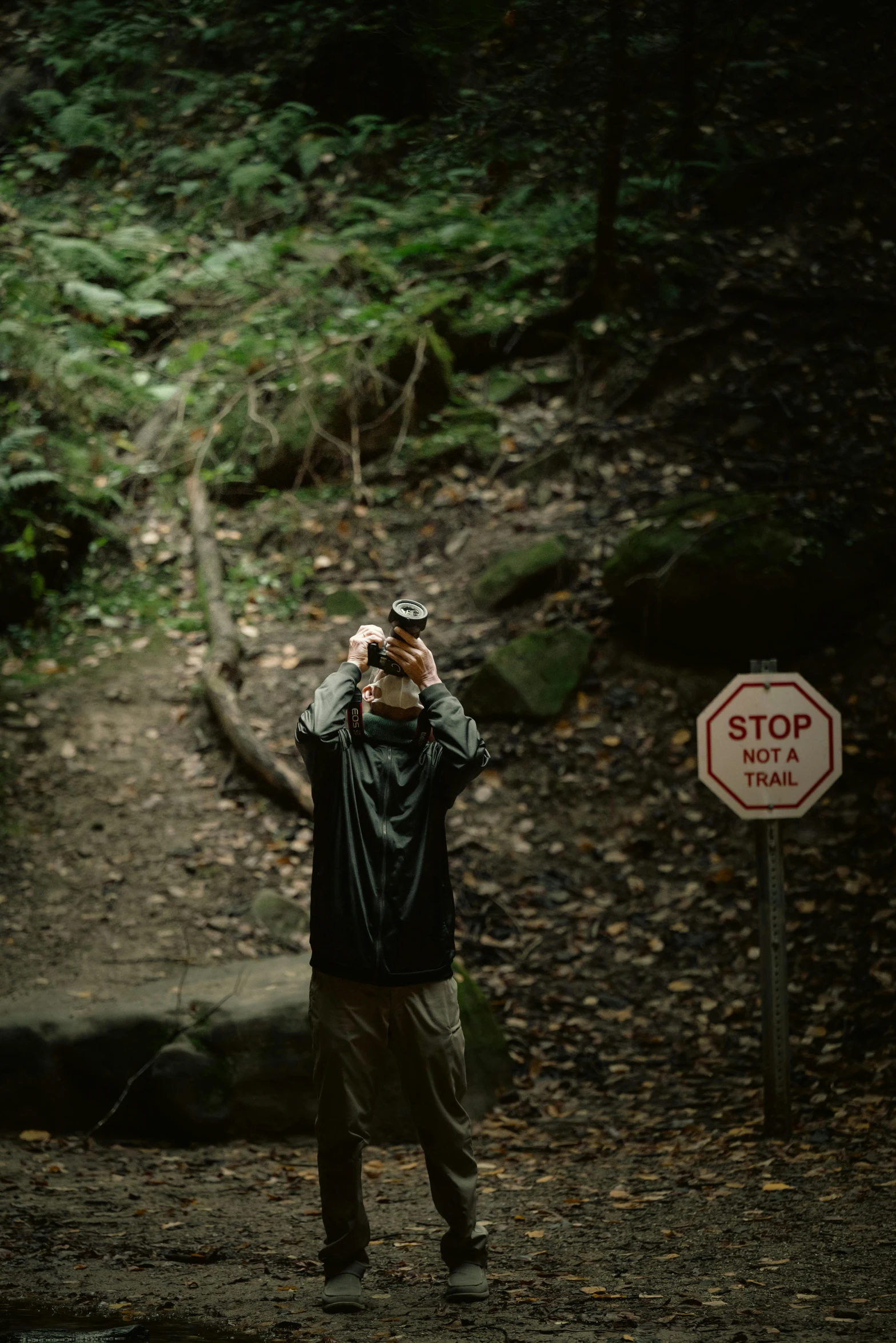 a person wearing a hat standing next to a sign