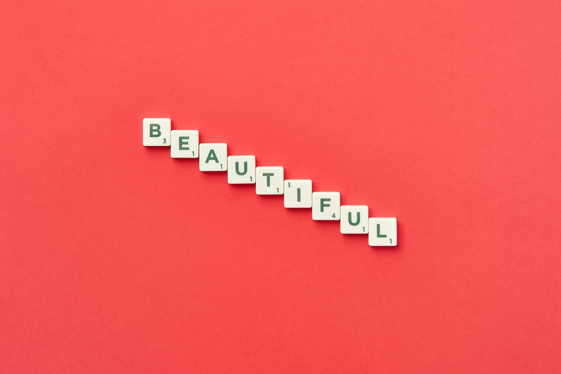 the letters beautiful spelled with wooden blocks on a red background