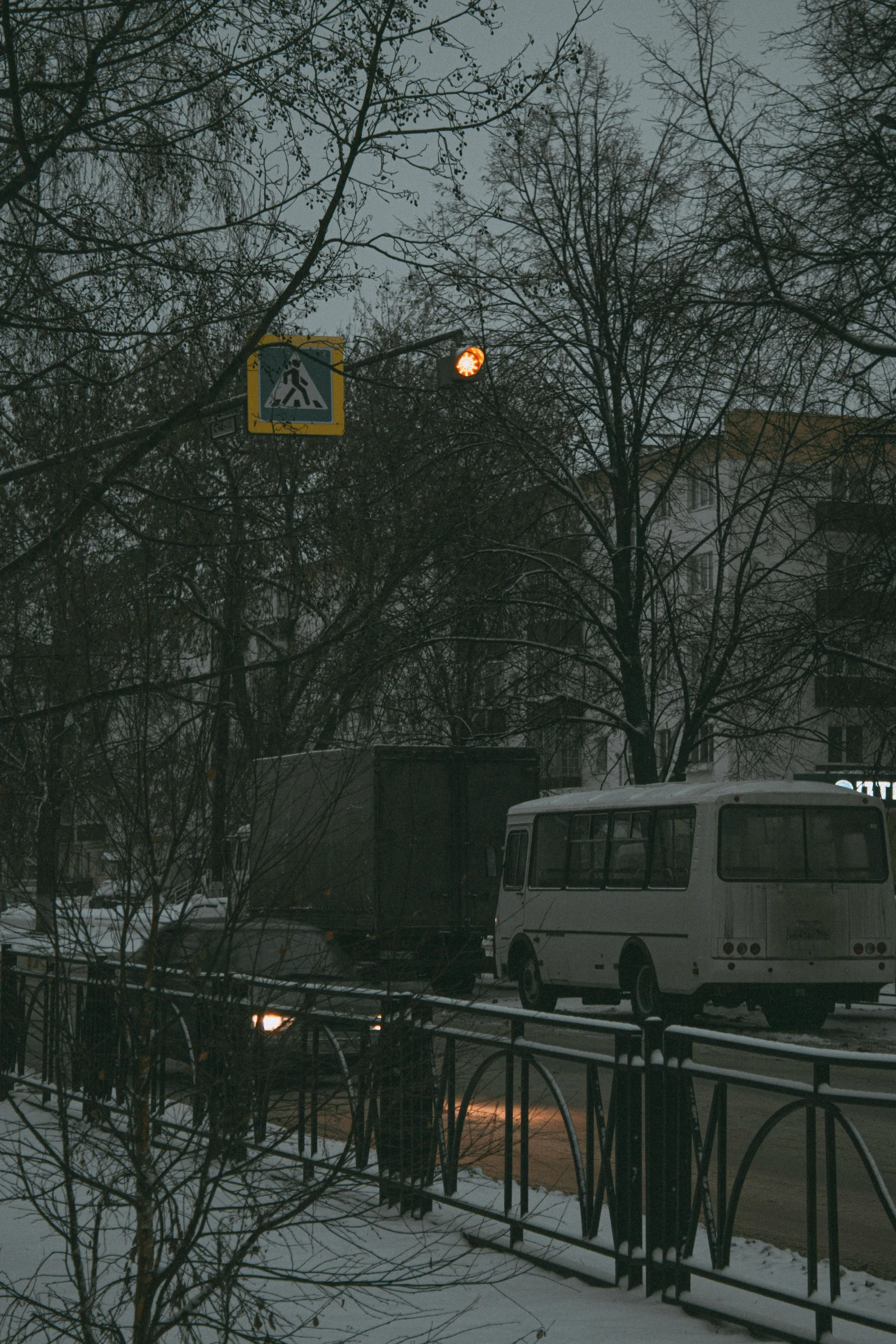 a white van parked in front of some trees covered in snow