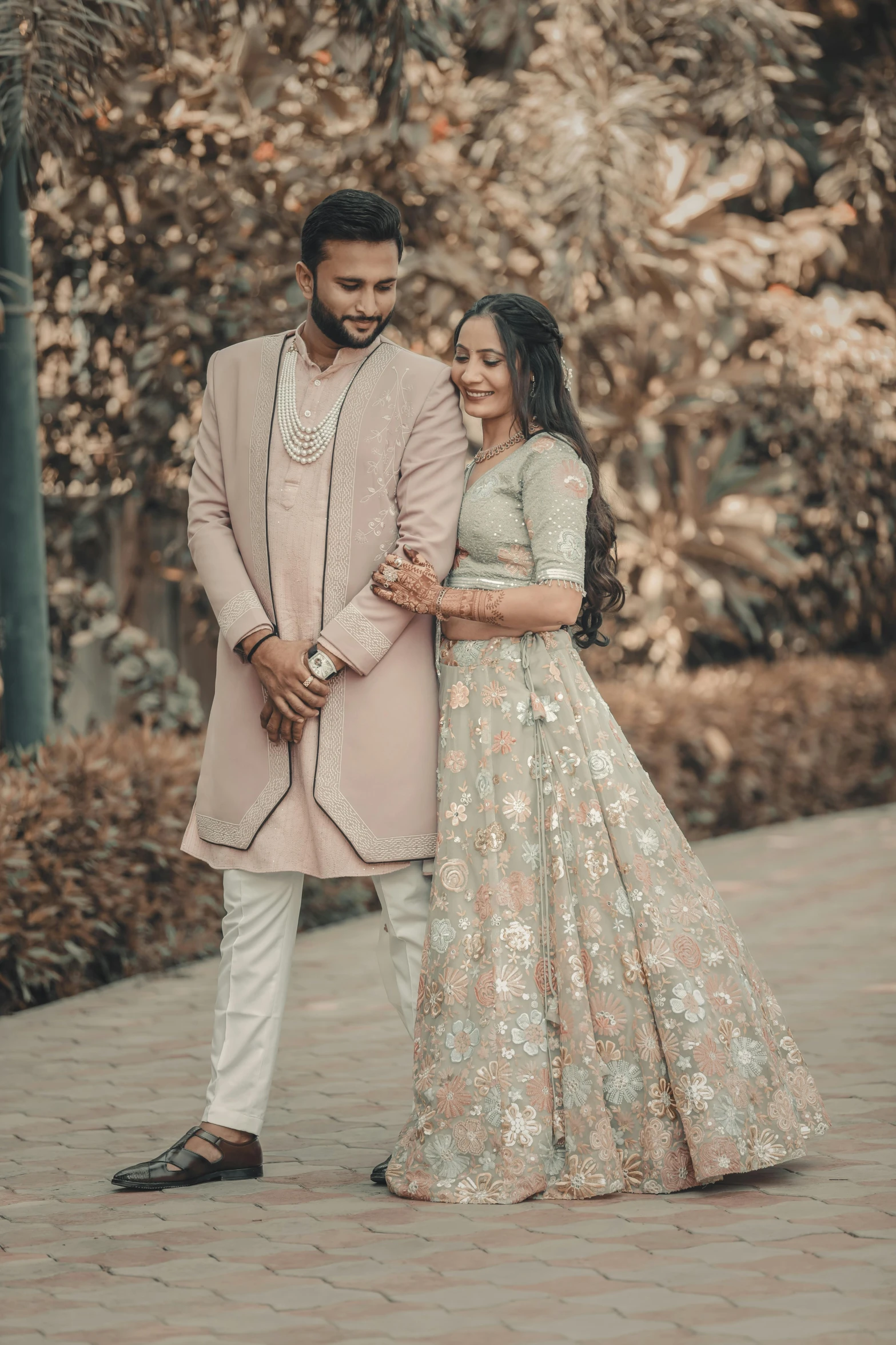 the bride and groom pose for a portrait in front of a group of trees