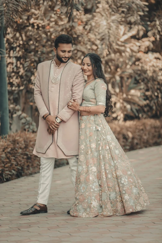 the bride and groom pose for a portrait in front of a group of trees