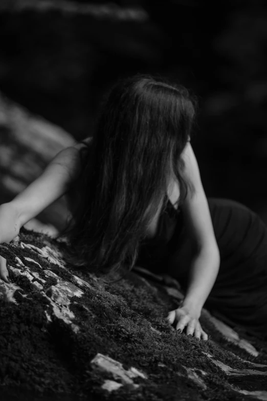black and white pograph of a woman leaning on a rock