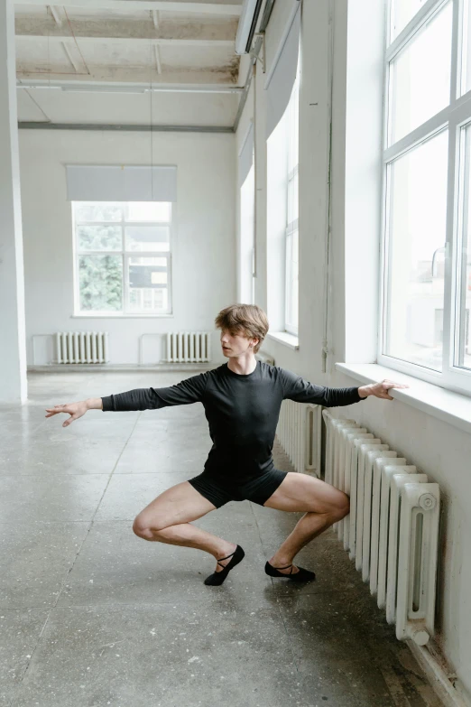 a woman stretching in a large building, her legs on the ground