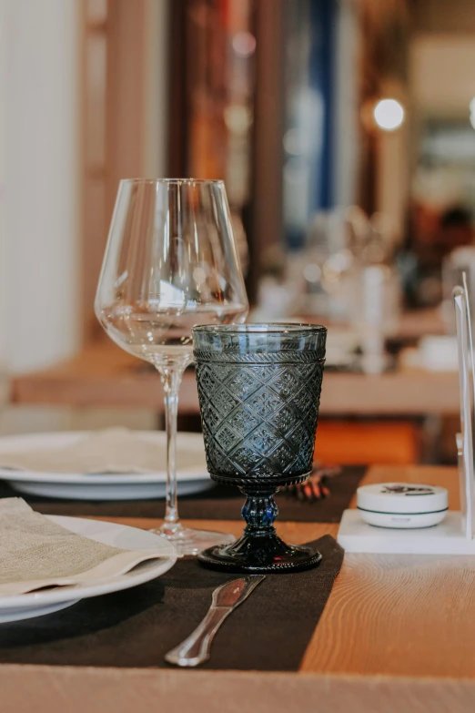 a dinner table with white place mats, silver dishes and silver cutlery