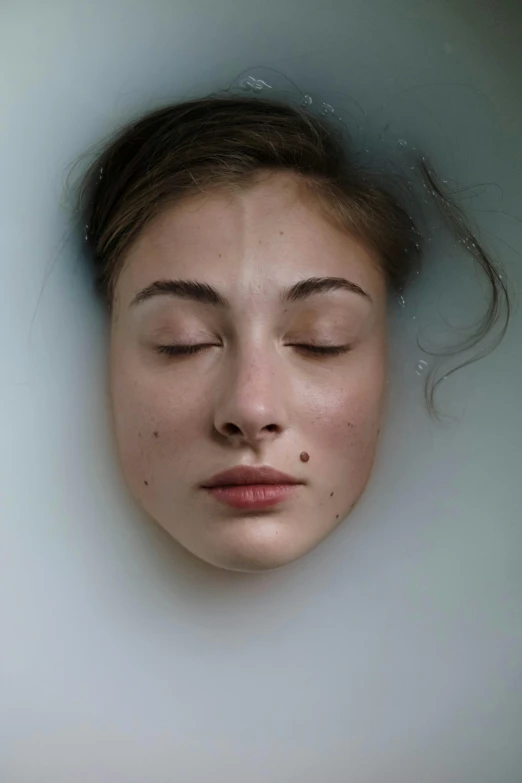 a woman with closed eyes sitting in a bubble