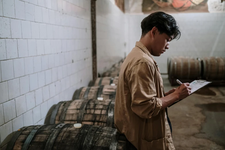 a man checking soing in front of barrels