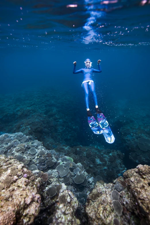 the man is paddling in the water with his surfboard