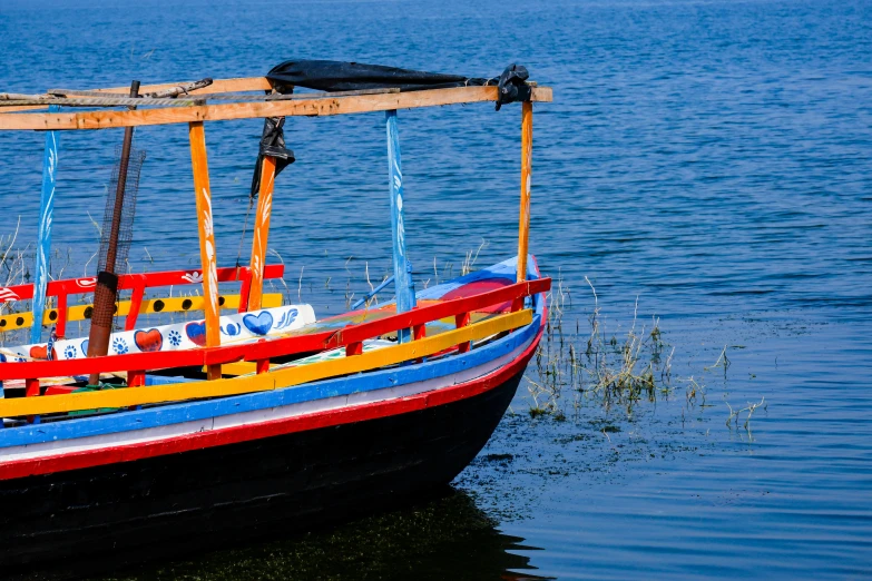 a brightly colored boat floating on top of the water