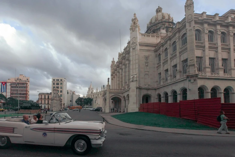 vintage cars drive down an old european street