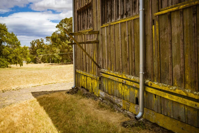 a brown barn with a gate in front of it