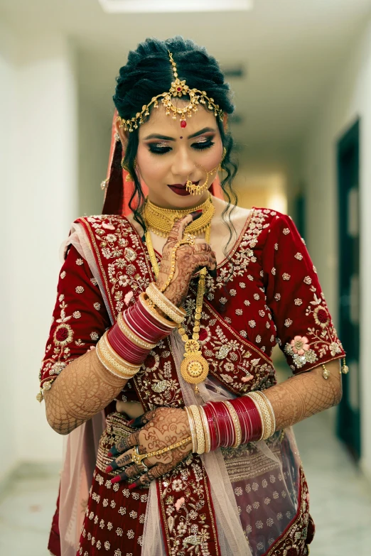 an indian bride with her jewelry on and a red and white outfit