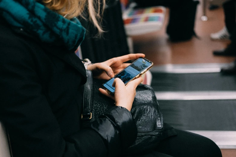 a woman looking at her cell phone while sitting