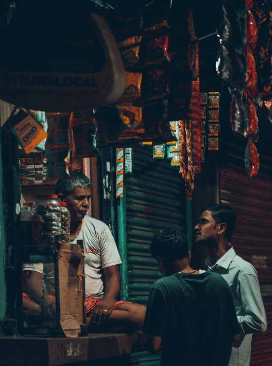 three men standing in front of a food market