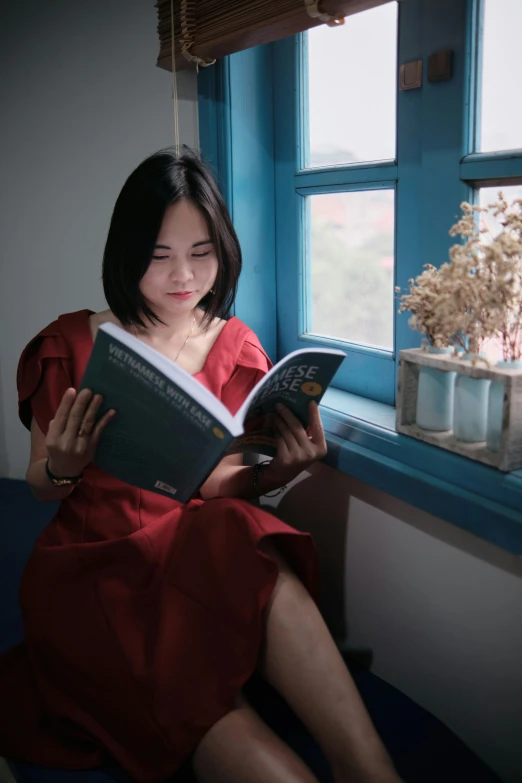 a woman sitting on a couch while reading a book