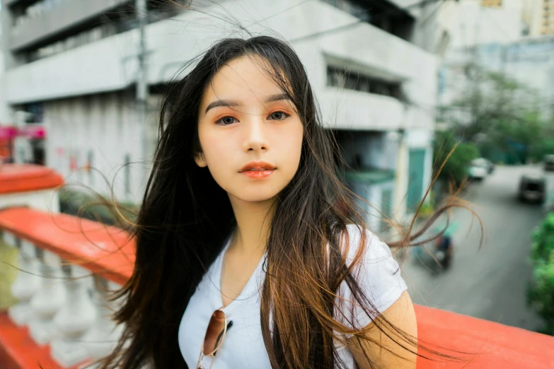 a woman with long hair posing on a bench