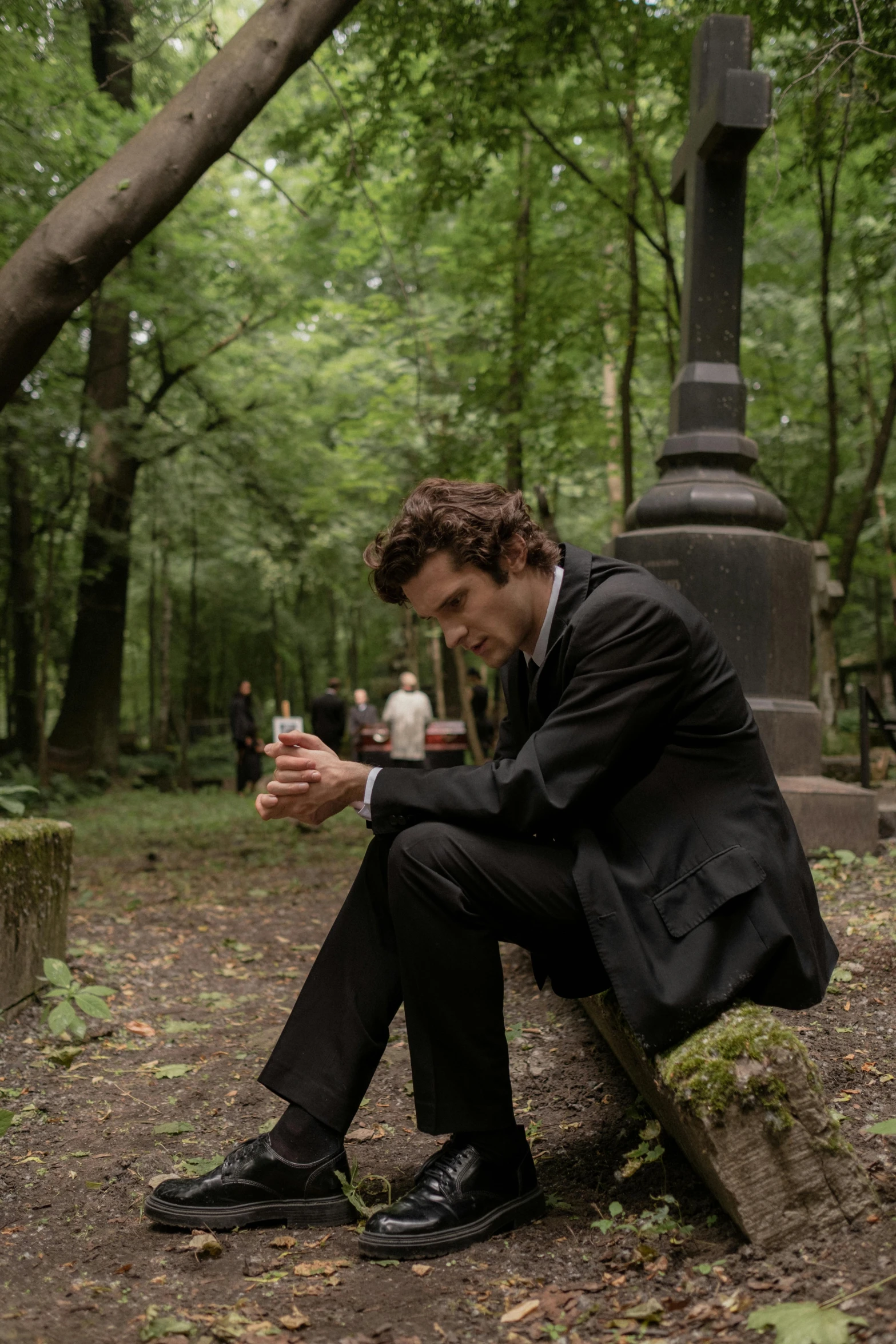 the young man is sitting on a bench looking at his cell phone