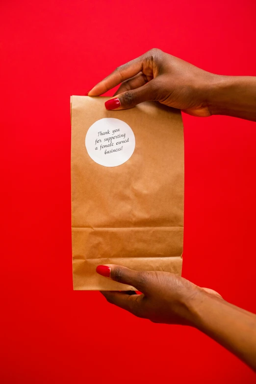 hands holding an envelope with a white circle sticker