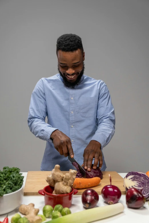 a man cuts up vegetables with scissors on a  board