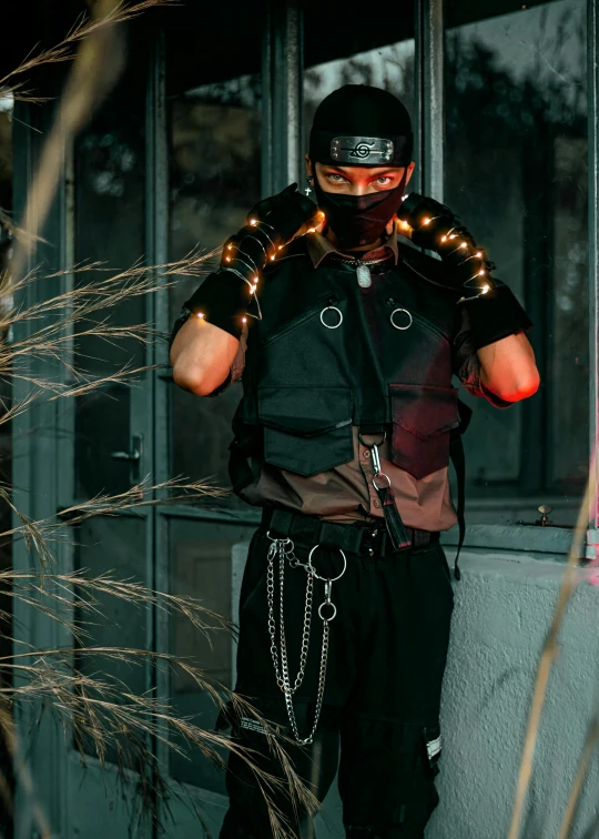 a masked man stands by a building window