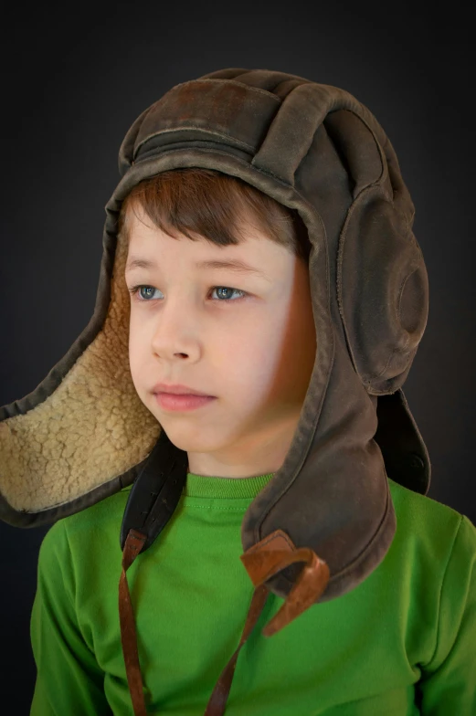 a little boy is wearing a large hat