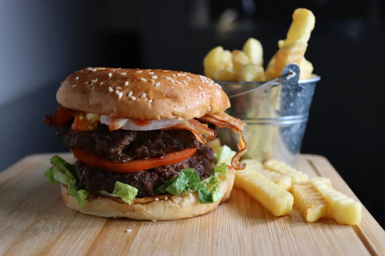 a hamburger is seen with lettuce, tomato and sauce