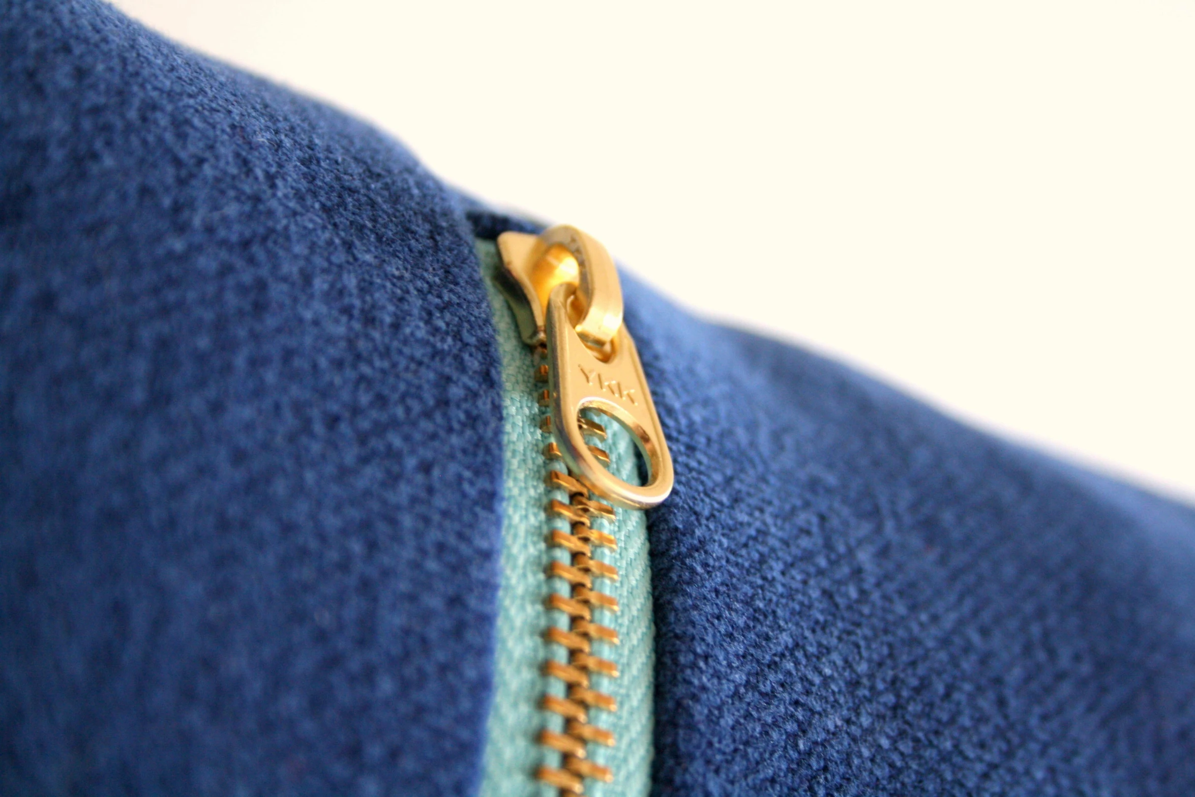 an up close po of the zipper of a blue sweatshirt