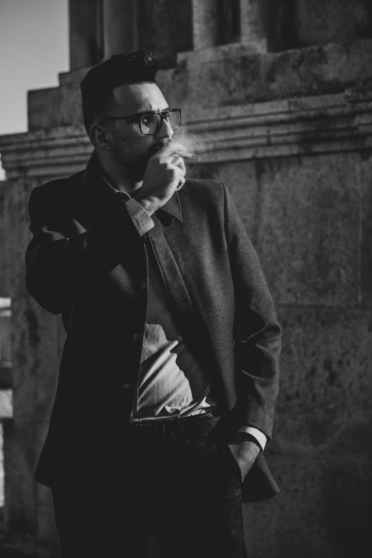 black and white pograph of man with beard and suit coat looking at camera