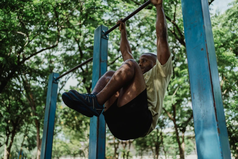 a man on a monkey bar doing handstand