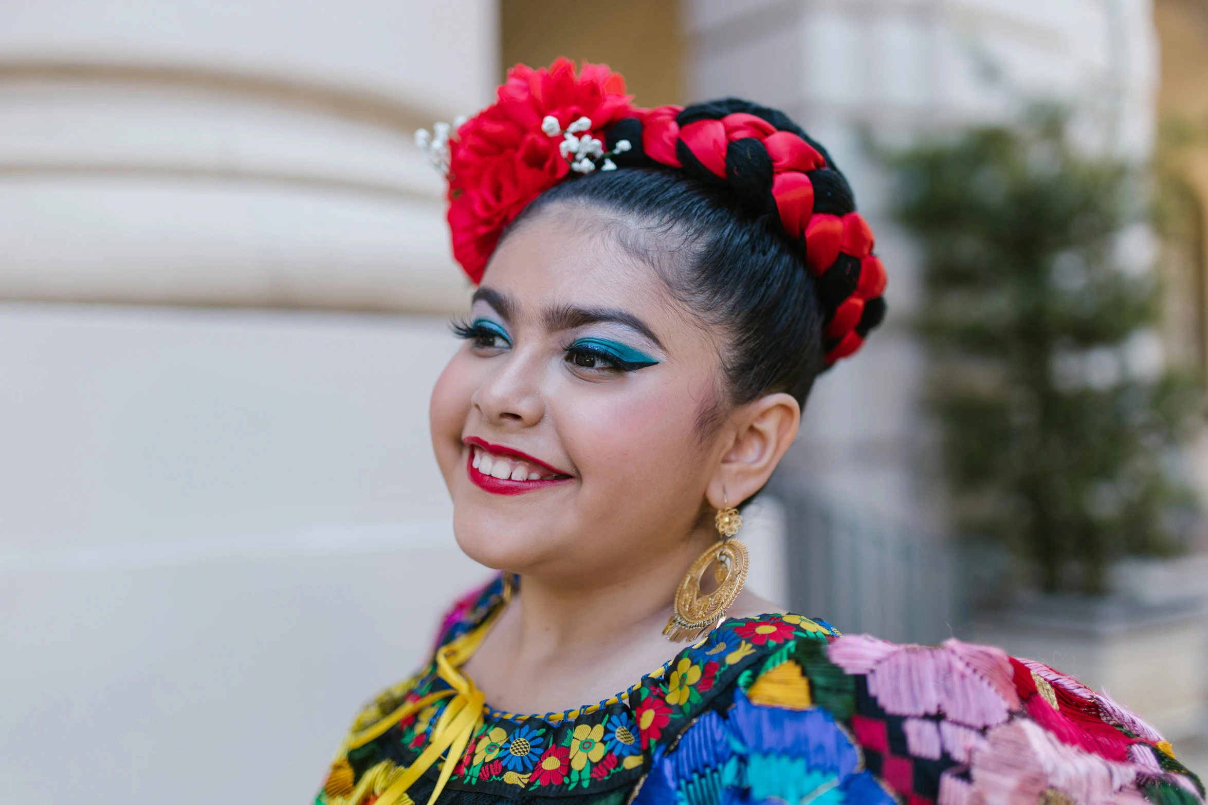 a woman is dressed with a head piece that has flowers in her hair