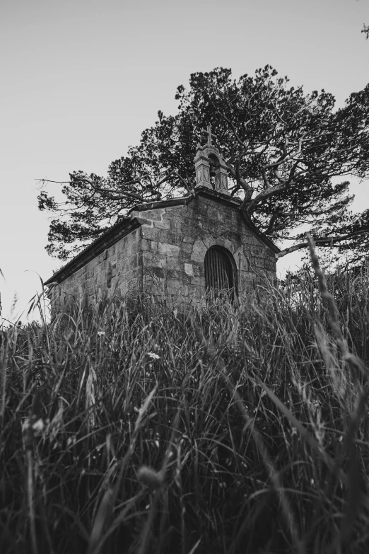 a small brick building sitting on top of a lush green field