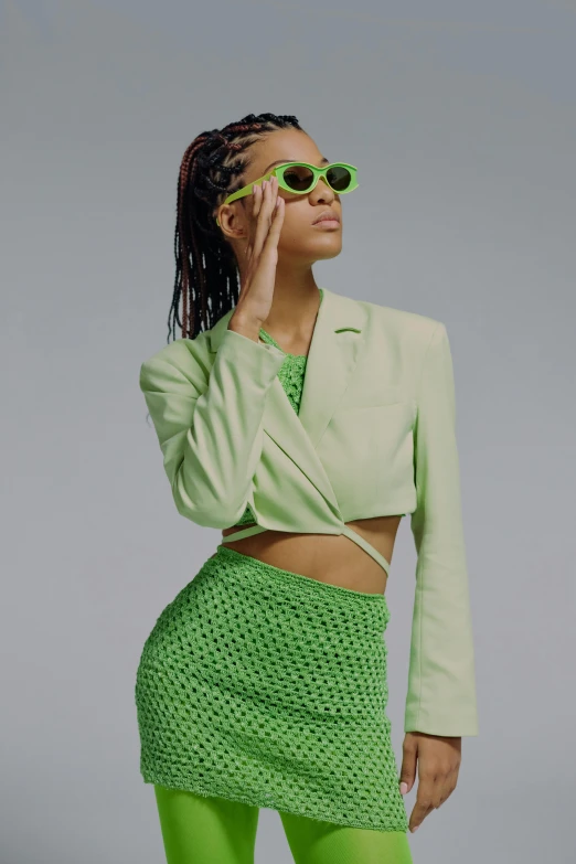 a woman with her hands in her pockets is wearing neon green clothes