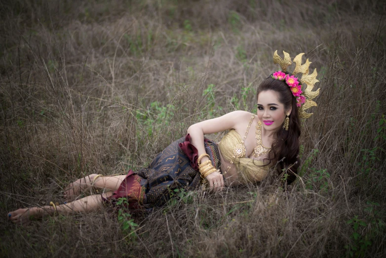 a woman is laying in some tall grass