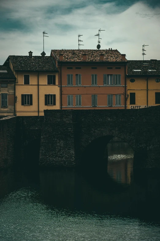 a brick bridge with buildings in the background