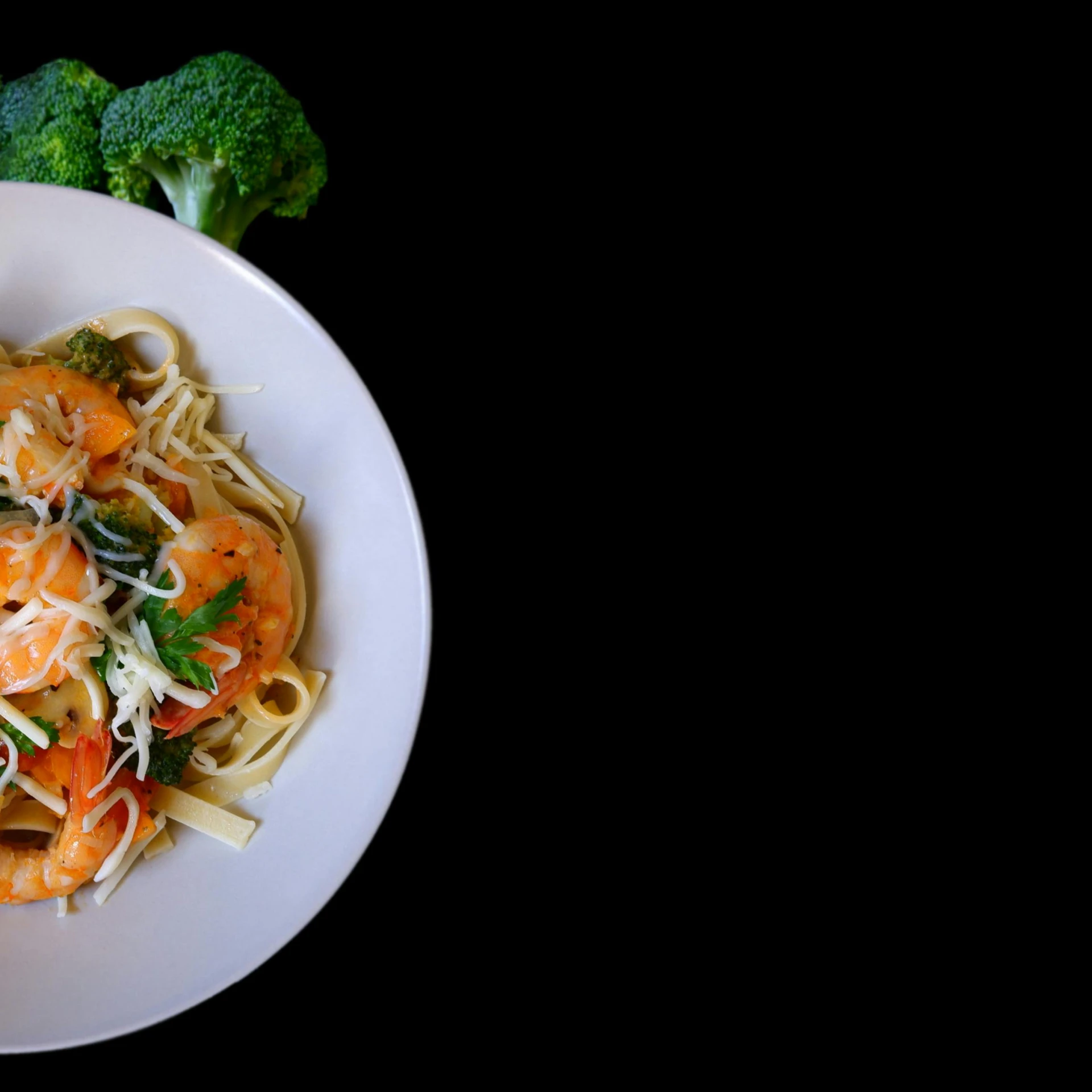 a bowl of pasta topped with shrimp and broccoli