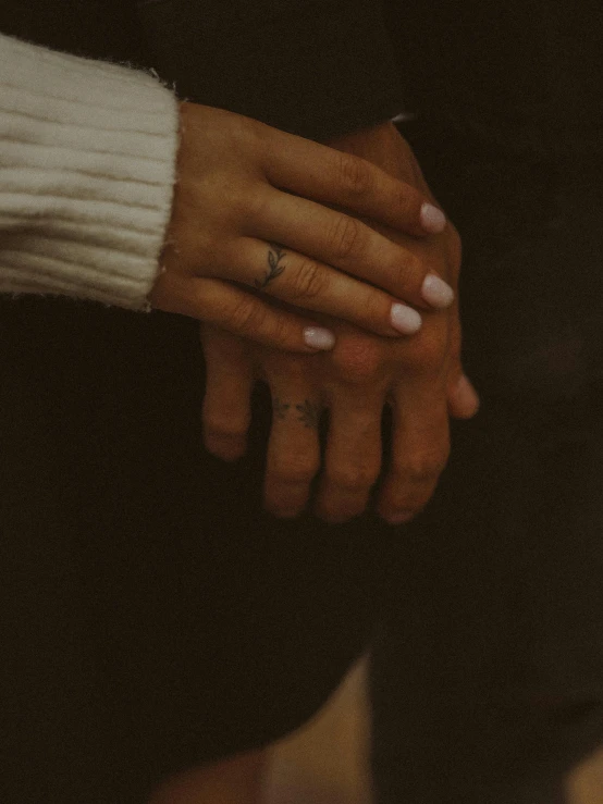 two people holding hands in front of a camera