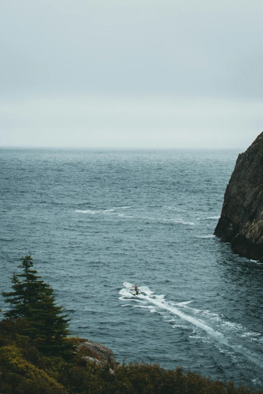 people on water skis near a rocky cliff