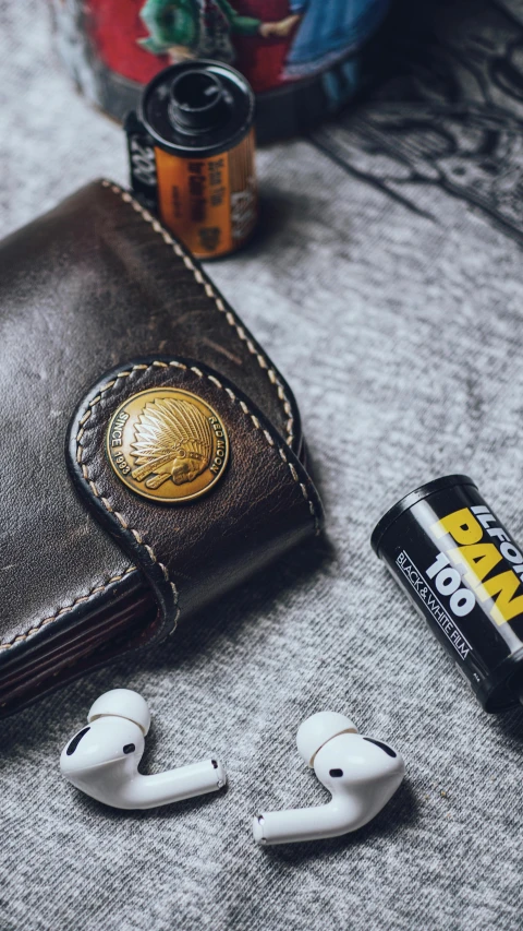 the back of a leather wallet with ear buds