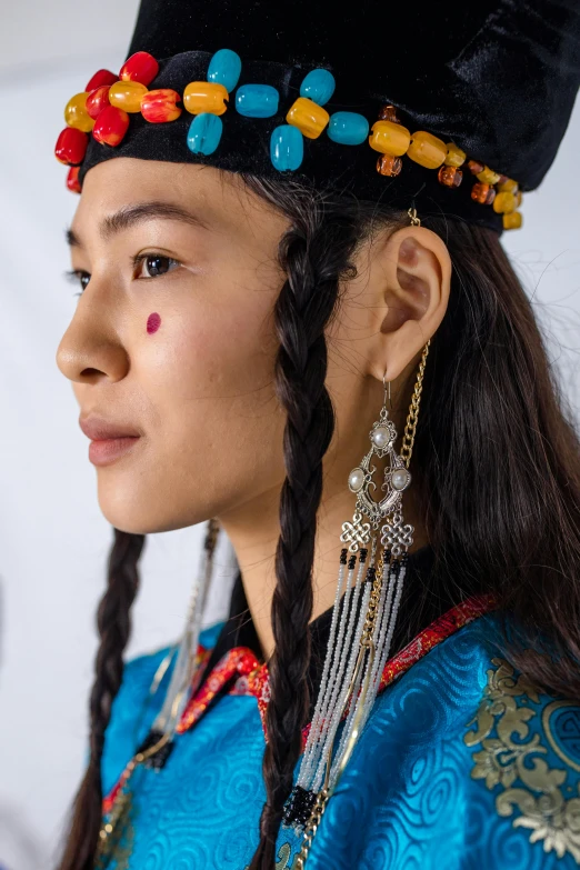 a woman wearing a black hat with beaded details and long ids