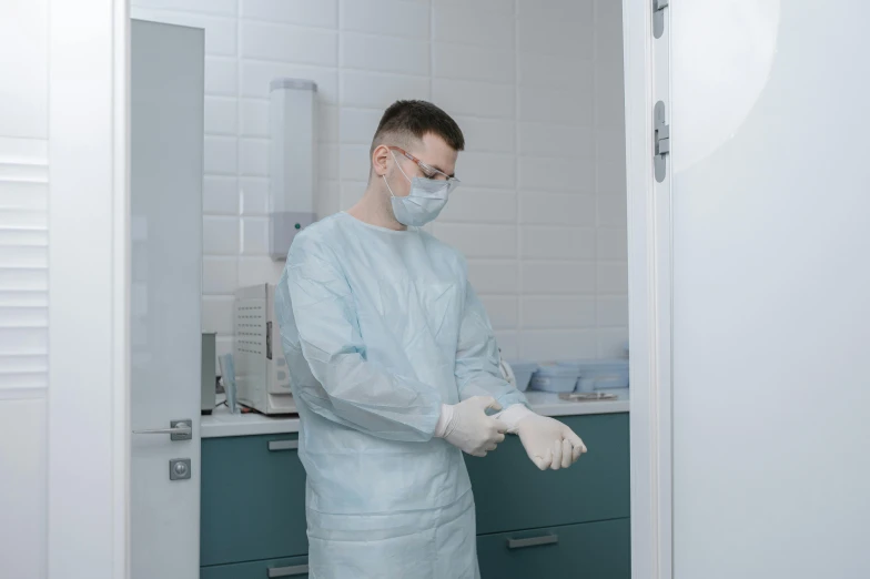 a man in white scrubbing clothing is standing next to the refrigerator