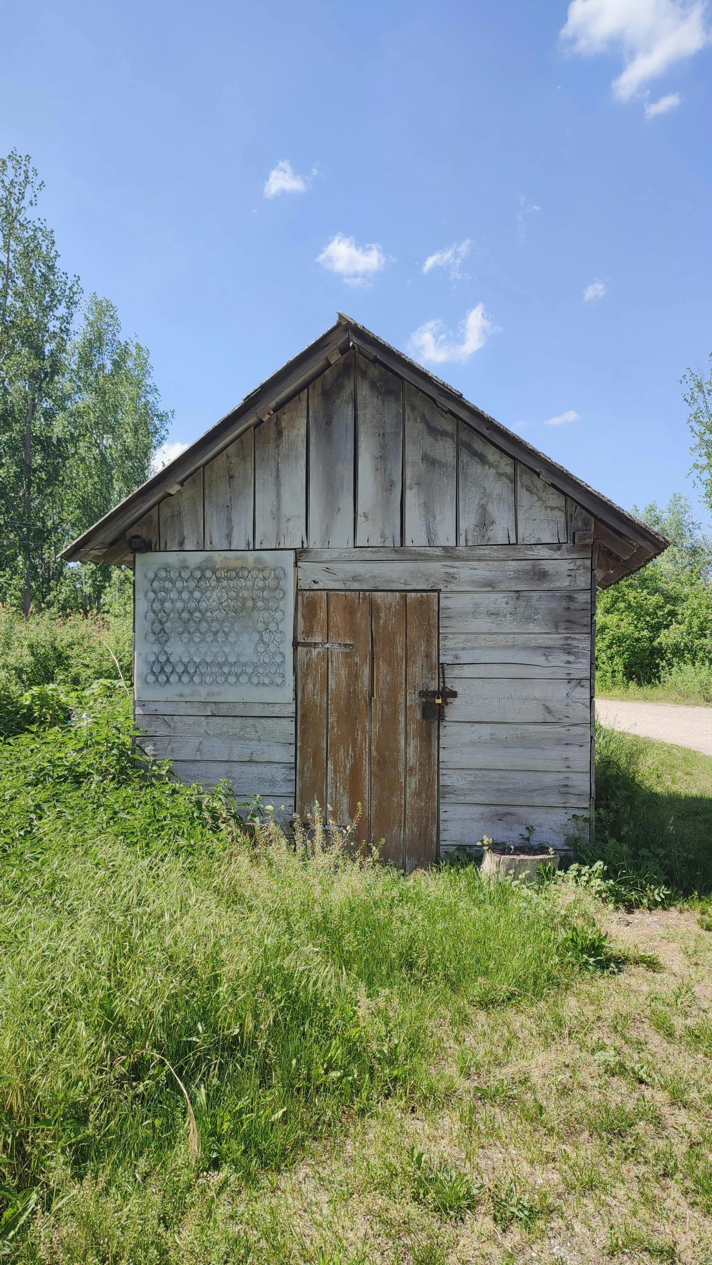 an old barn with doors sits in the middle of the countryside