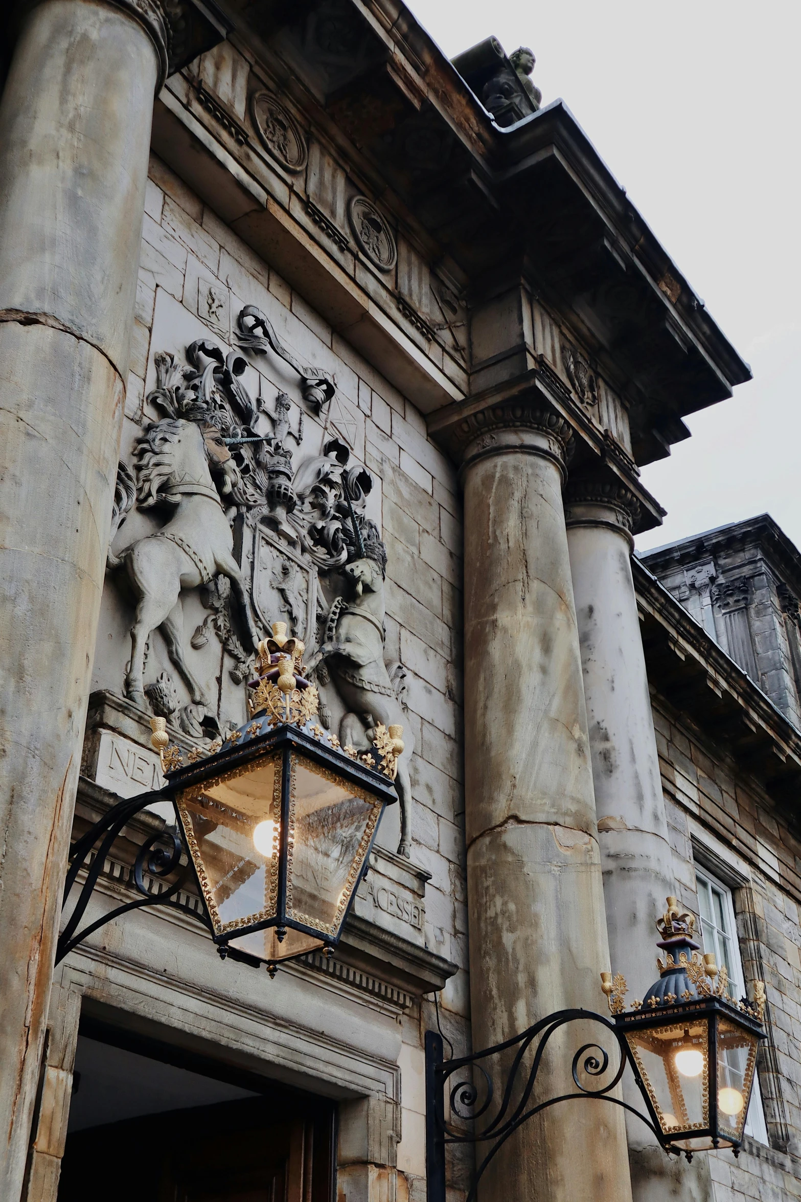 two tall stone pillars are below a large building