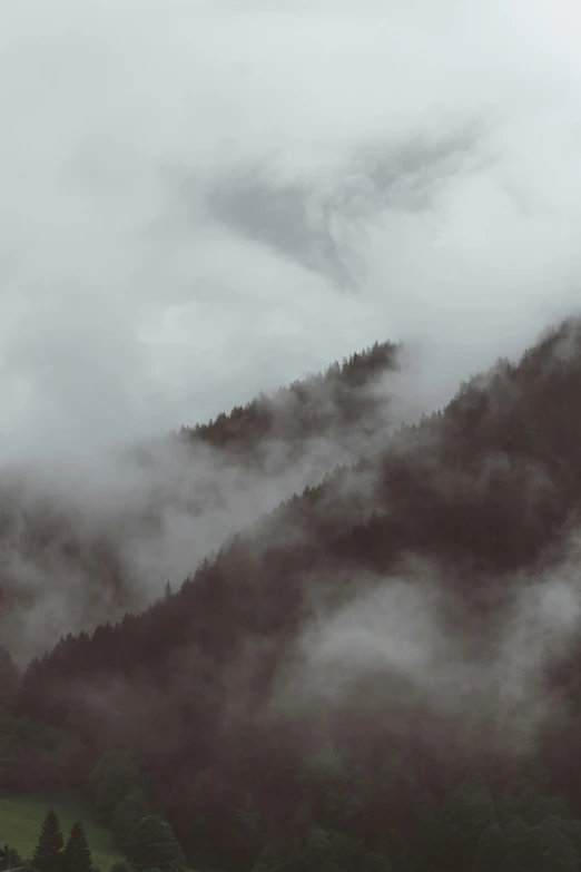 a black and white po of a cloud covered mountain